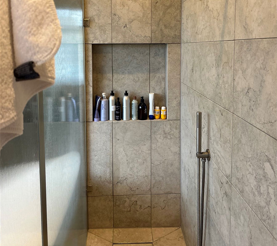 Walk-in shower with a full-width tiled niche